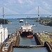 A view of the entrance to the Panama canal, with several ships and other forms of infrastructure in the background