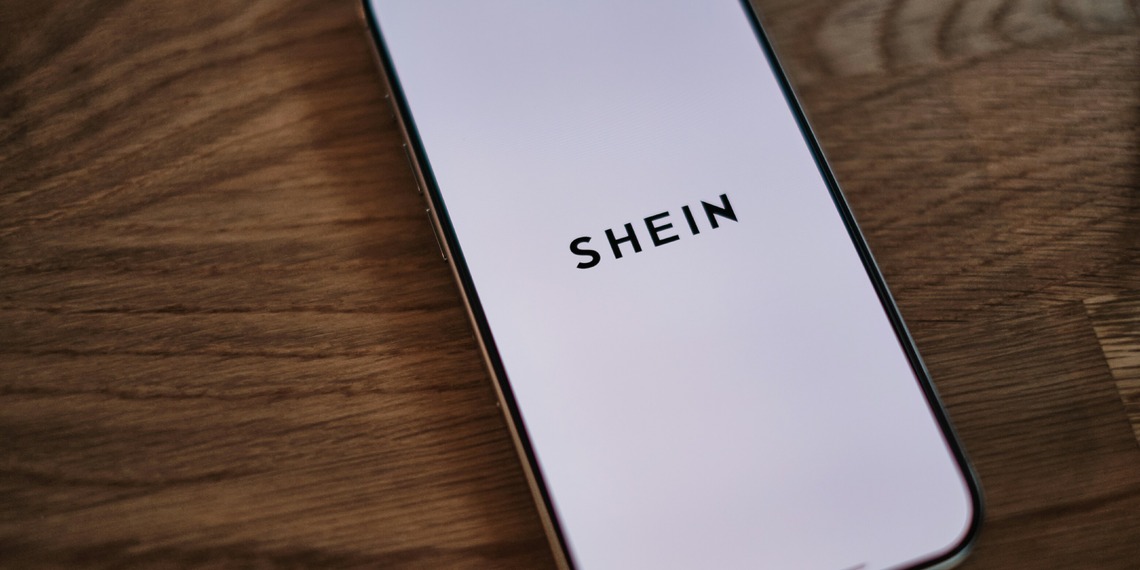An Iphone sitting on the table with the SHEIN app open