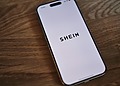 An Iphone sitting on the table with the SHEIN app open