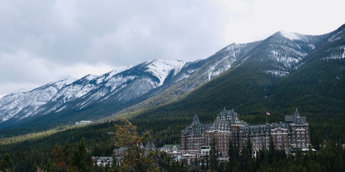 Banff Springs Hotel surrounded by trees and mountains in Alberta, Canada