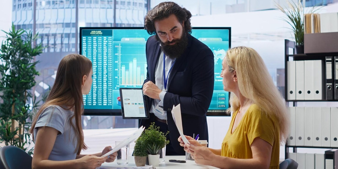 Business professional presenting accounting software to colleagues in an office