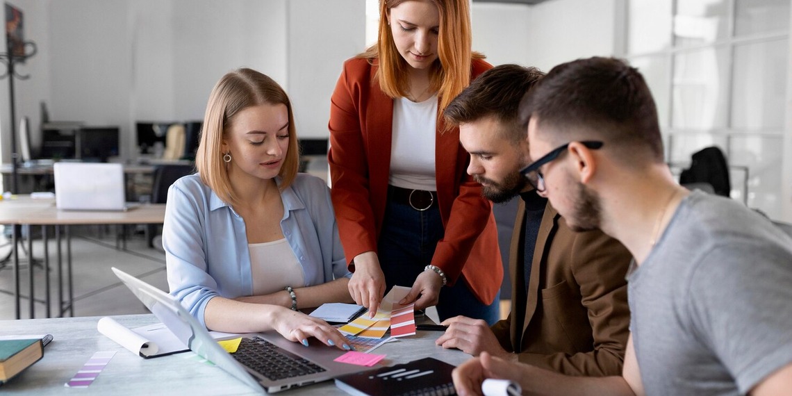 Marketing team reviewing brand materials and campaign ideas around a table