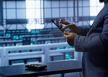 Professional using a tablet beside modular fintech infrastructure