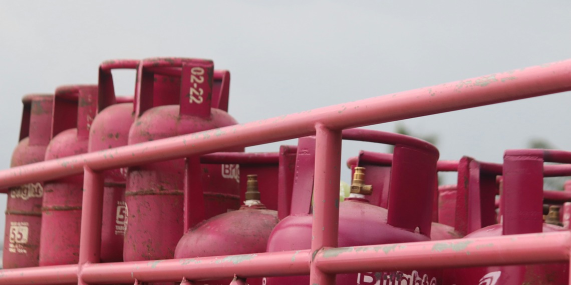 A group of pink gas tanks sitting next to each other