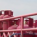 A group of pink gas tanks sitting next to each other
