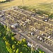 An aerial shot of a power station with greenery of rural England in the background