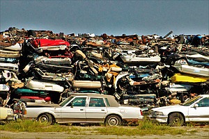 Disposed vehicles piled up in a junkyard.