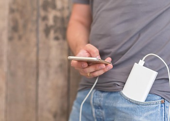 Person charging a smartphone with a portable power bank