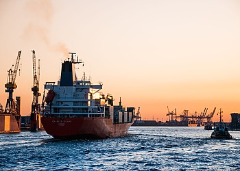 Stunning sunset view of cargo ships and cranes at the Port of Hamburg, epitomizing global trade and logistics.