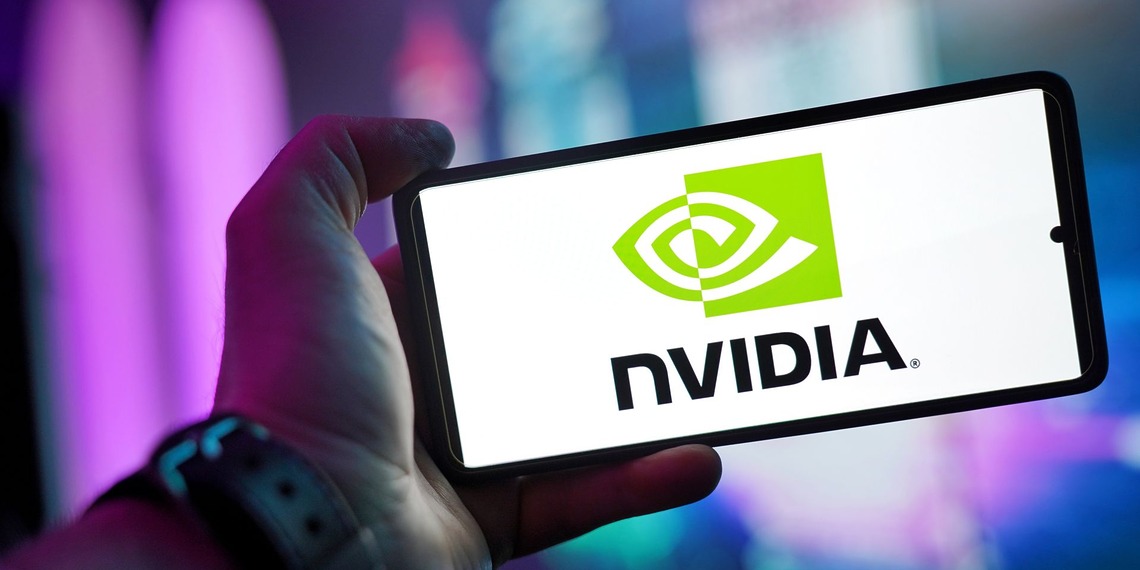 Close-up of a hand holding a smartphone showing the NVIDIA logo on screen with a blurred background.