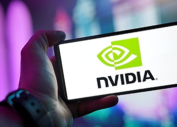 Close-up of a hand holding a smartphone showing the NVIDIA logo on screen with a blurred background.