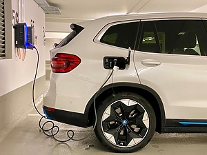 A white electric SUV plugged in for charging