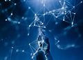 A robotic hand reaching into a digital network on a blue background.