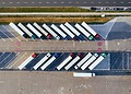 A aerial shot of semi-trucks parked diagonally in a lot.