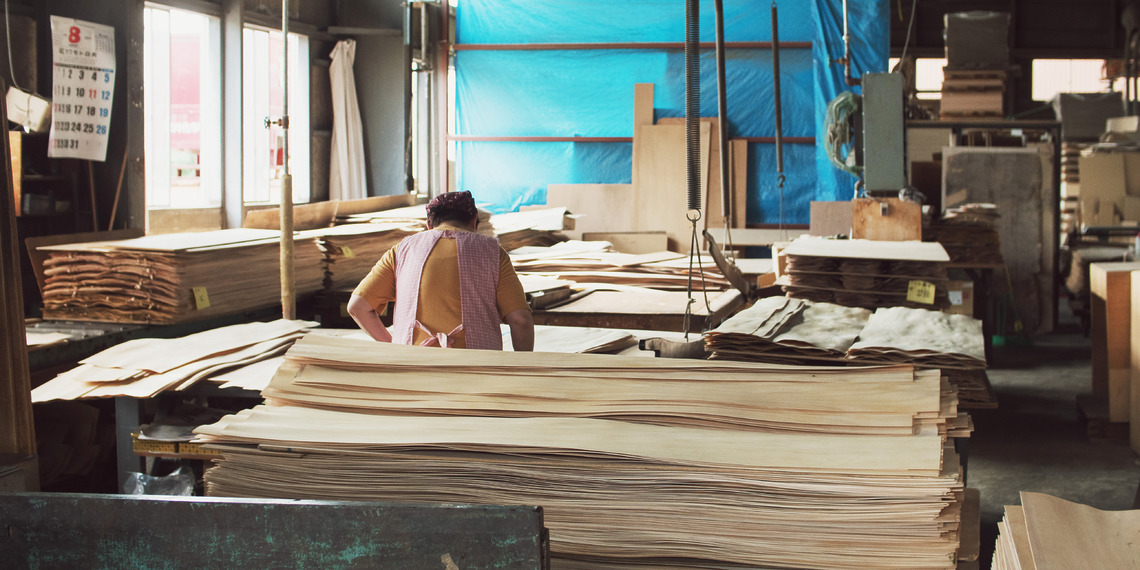 A skilled woodworker carefully grades veneer by eye for its beauty and appearance.