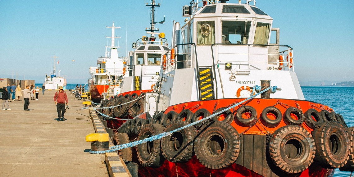 Red and white tugboats docked in a harbor.
