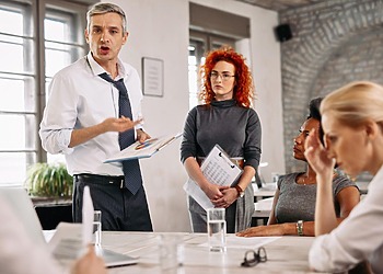 Business leaders reviewing workforce reports during a boardroom meeting