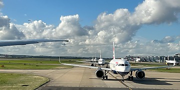 A picture of airplanes lined up at the runway at Heathrow Airport.