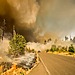 A white pick-up truck drives through a forest fire in Lowell, USA.