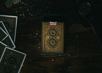 Antique hand painted playing cards laid out on a dark table