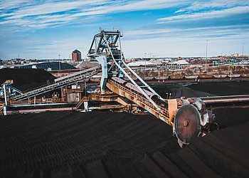 Machinery processing coal at a stockpile site.