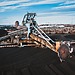 Machinery processing coal at a stockpile site.
