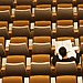 Person reading in an empty lecture hall.