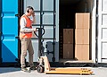 Worker standing beside an open shipping container with stored materials inside