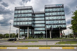 A sleek, modern office building in Zagreb, Croatia under a cloudy sky, reflecting urban architecture.