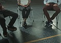 A group of three adults sitting in chairs during a discussion or support session indoors.