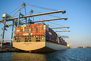A large container ship at an industrial harbor.