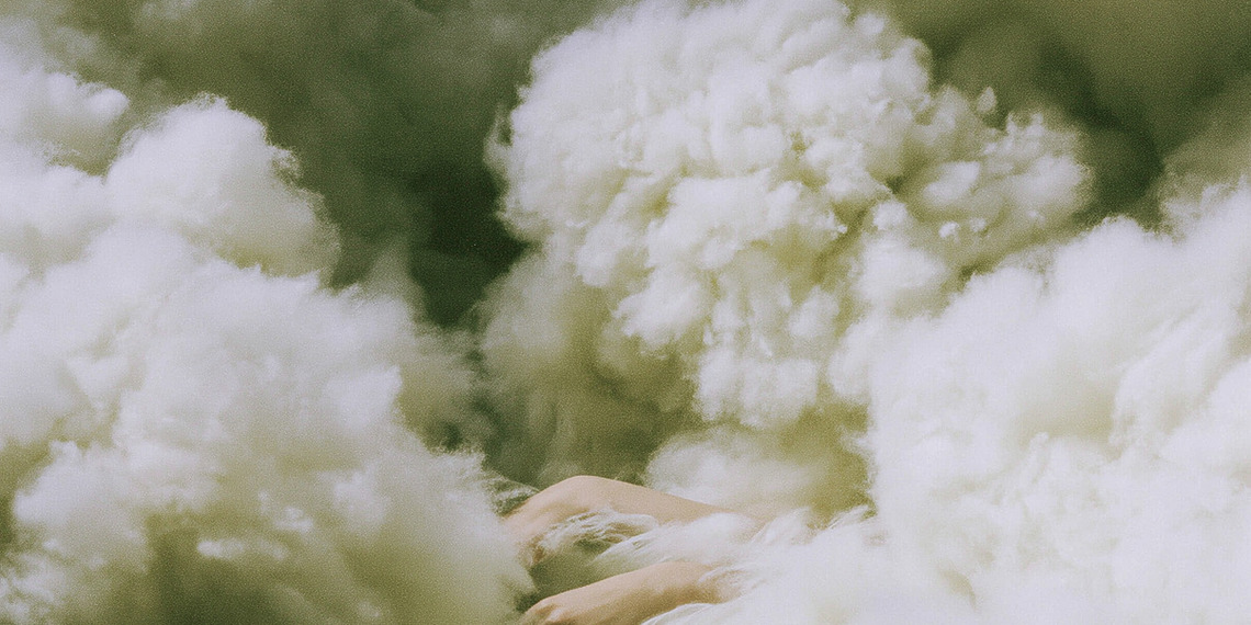A figure hidden among "clouds" of wool.