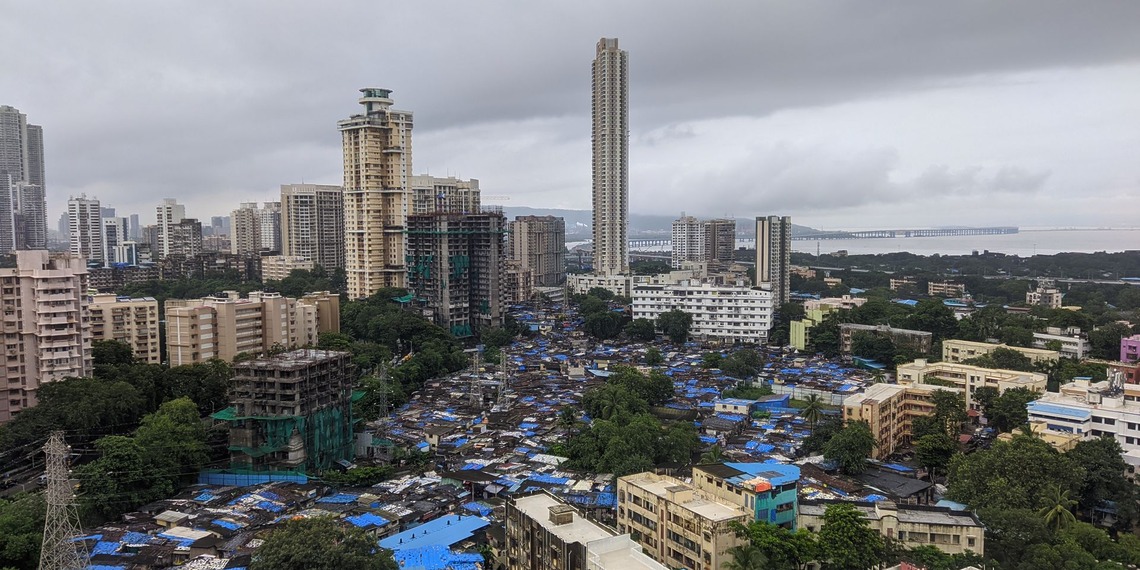 An informal settlement sits beside high-rise towers in Mumbai,
