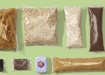 Diverse food products are presented in plant-based plastics.