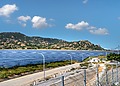 A vast solar farm with solar panels under a bright blue sky in the mountains.