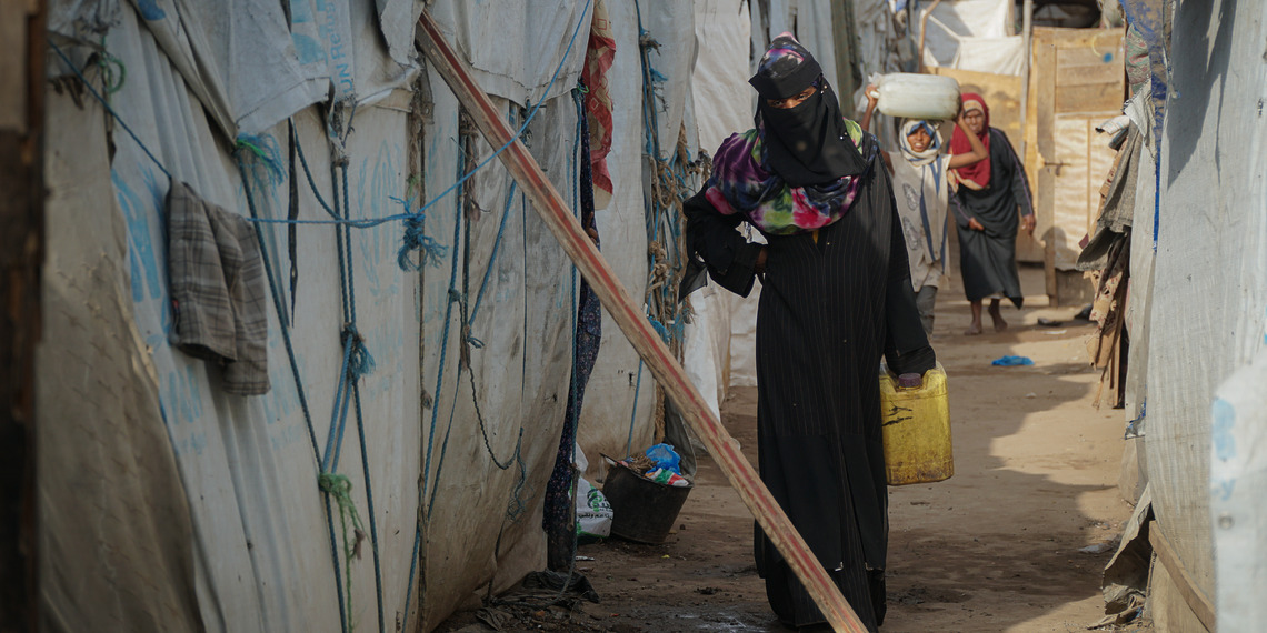 Aisha, a pregnant internally displaced person, going back into her shelter after getting water in Ammar Bin Yasser Camp in Aden, Yemen, Feb. 28, 2022.