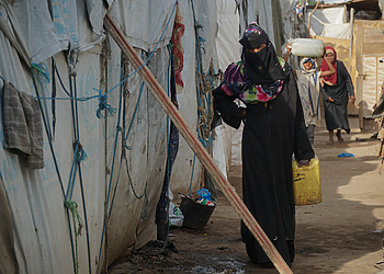 Aisha, a pregnant internally displaced person, going back into her shelter after getting water in Ammar Bin Yasser Camp in Aden, Yemen, Feb. 28, 2022.