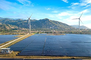 Solar panels and wind turbines stand side by side.
