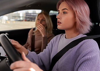 Concerned driver and passenger reacting inside a moving vehicle