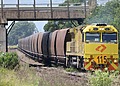 A yellow locomotive pulling coal wagons in New South Wales, Australia.