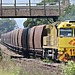 A yellow locomotive pulling coal wagons in New South Wales, Australia.