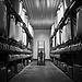 Rows of pressurized industrial refrigerant cylinders stored in a warehouse setting, representing the global chemical supply chain.