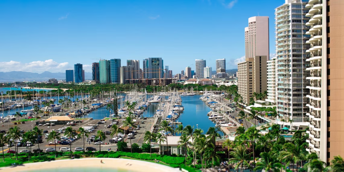 High-rise buildings line a coastal bay beside blue water.
