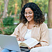 Graduate student studying online with a laptop and textbook
