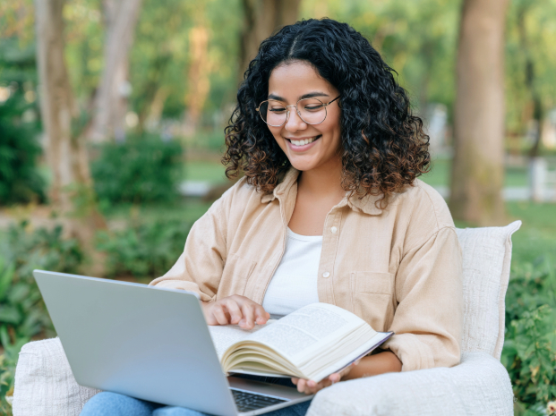 Graduate student studying online with a laptop and textbook