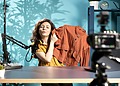 Podcast creator recording content beside branded clothing merchandise