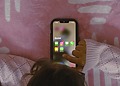 Small child using a smartphone, showing social media apps.