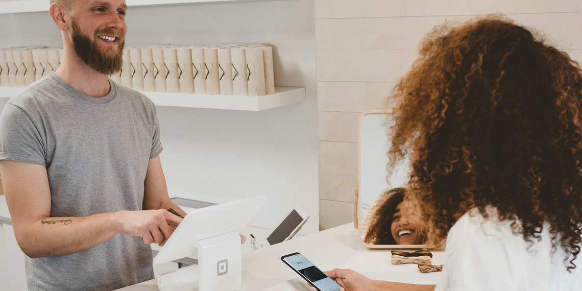 Customer speaking with an employee across a shop counter
