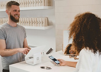 Customer speaking with an employee across a shop counter