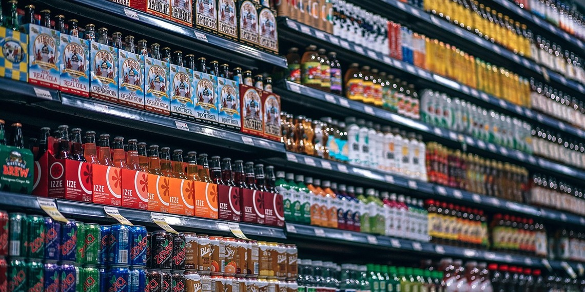 Bottled and canned beverages displayed on supermarket shelves